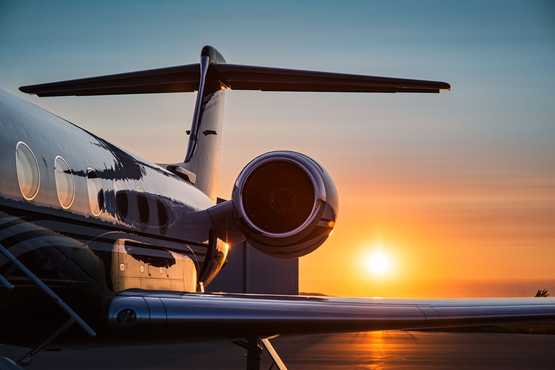 Private Jet Silhouetted Against Sunset on Tarmac